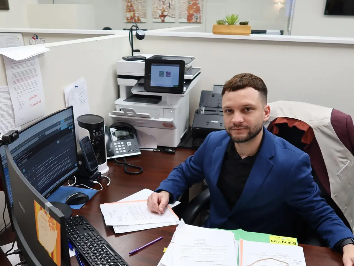 A staff member working at his desk with case files at the firm's Miami office