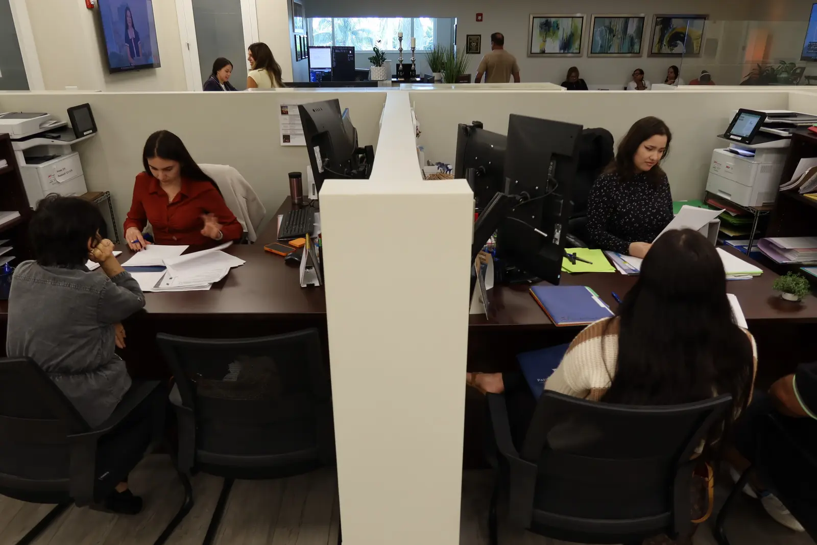 Miembros del equipo del bufete trabajando con expedientes de clientes en la oficina de Miami